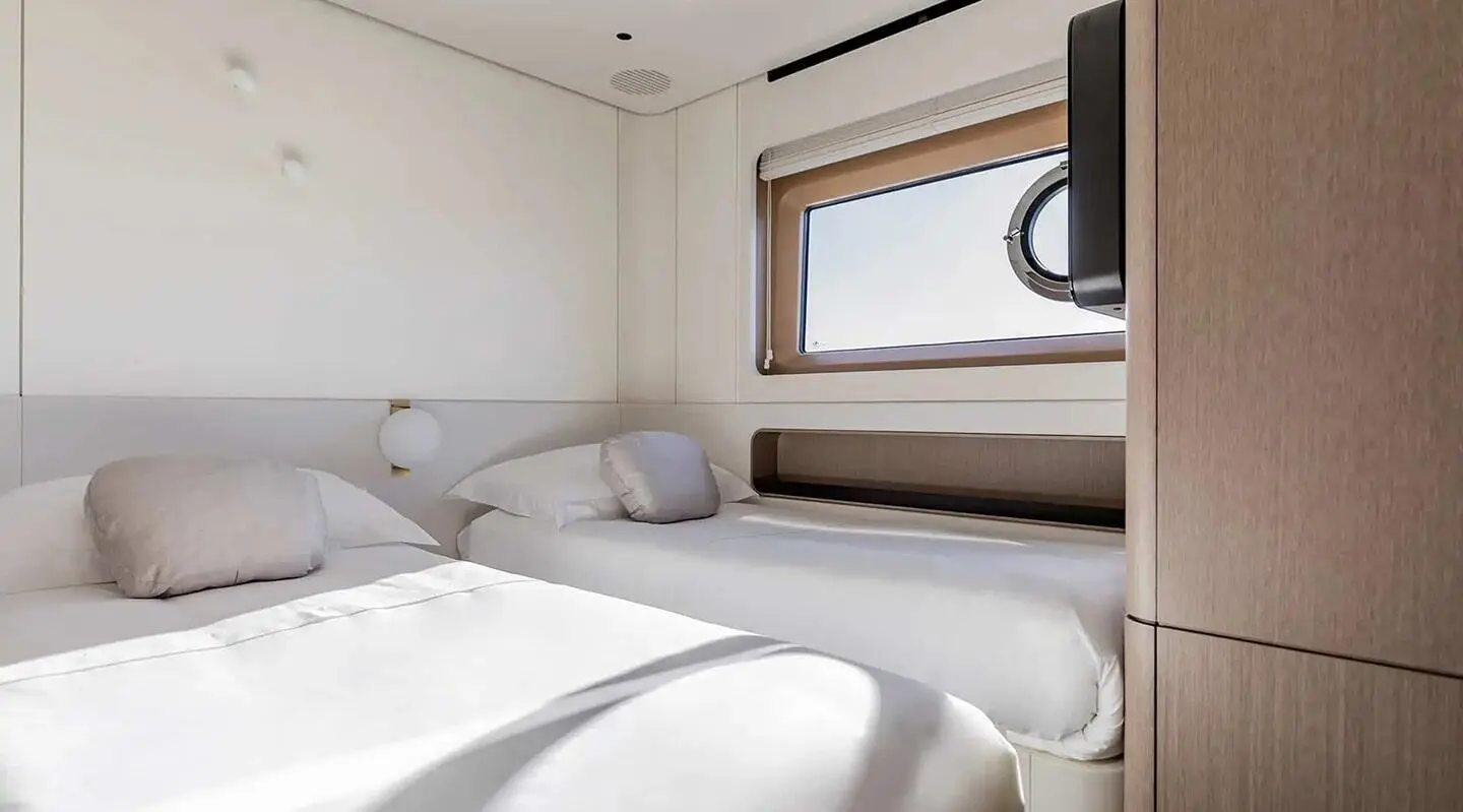 Viva II luxury yacht interior with two white beds, cushions, and a window view