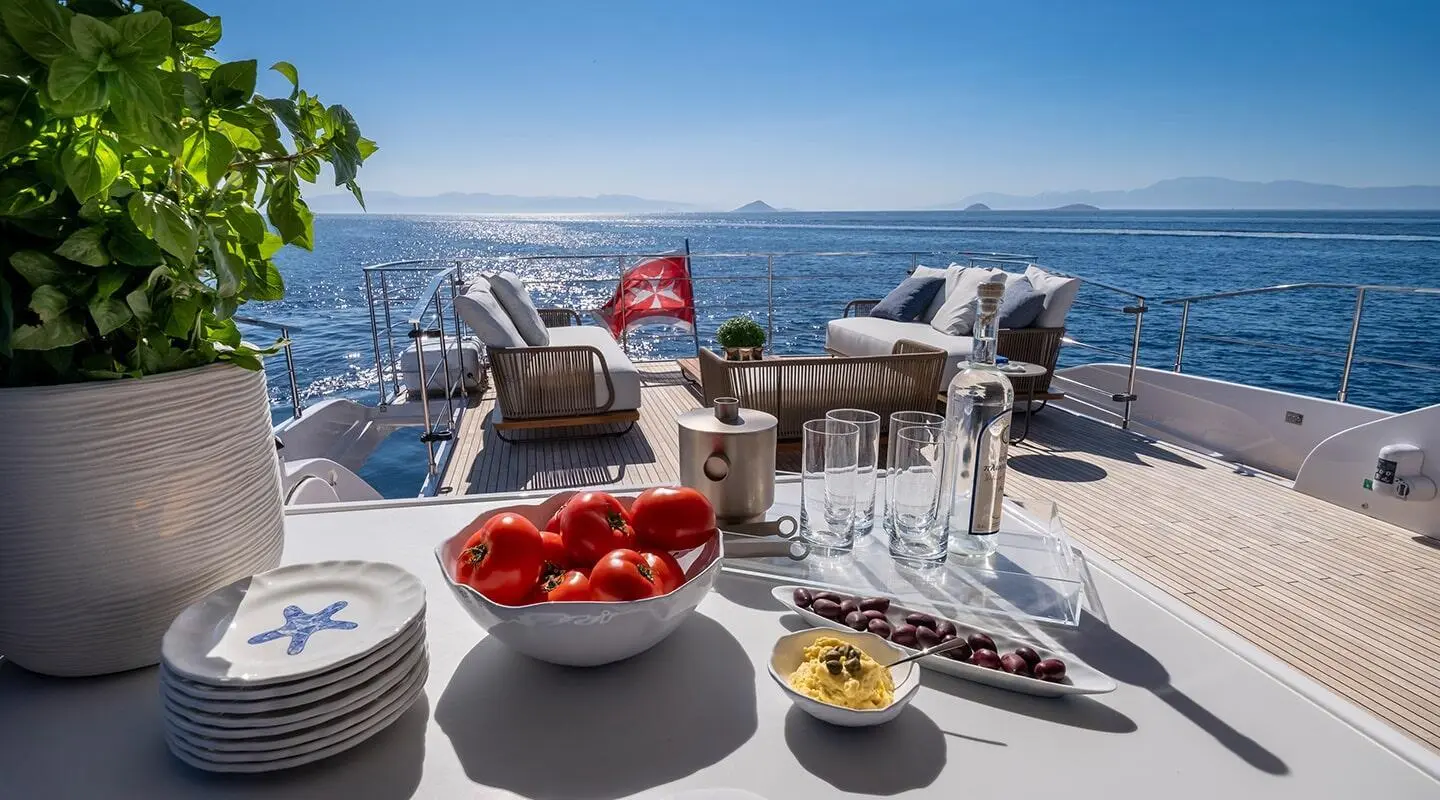 Spica luxury motor yacht deck with seating, bowls, and blue ocean backdrop
