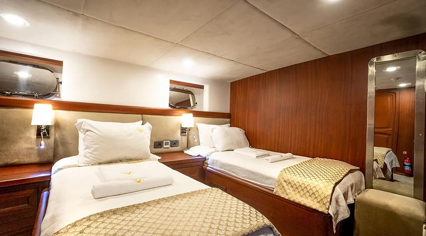 Luxurious yacht Virtuoso interior with two single beds, warm wood paneling