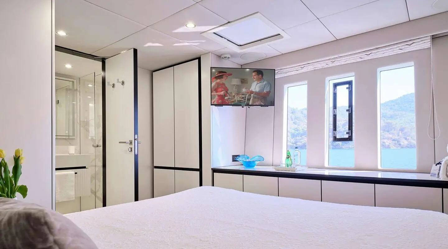 Genny yacht interior with double cabin, white bedding and blue accents