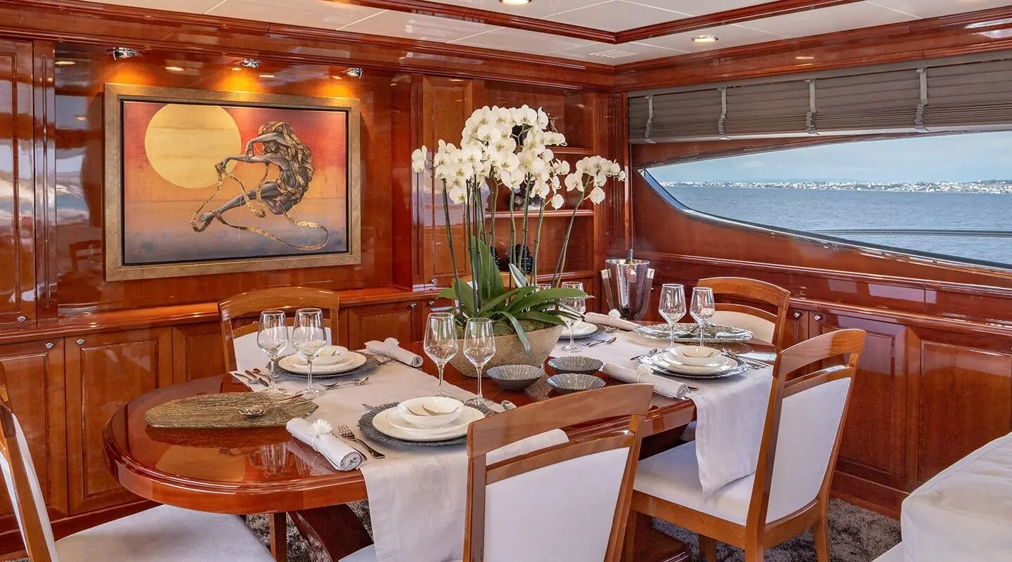 Elegant yacht dining saloon with white-draped tables and flowers