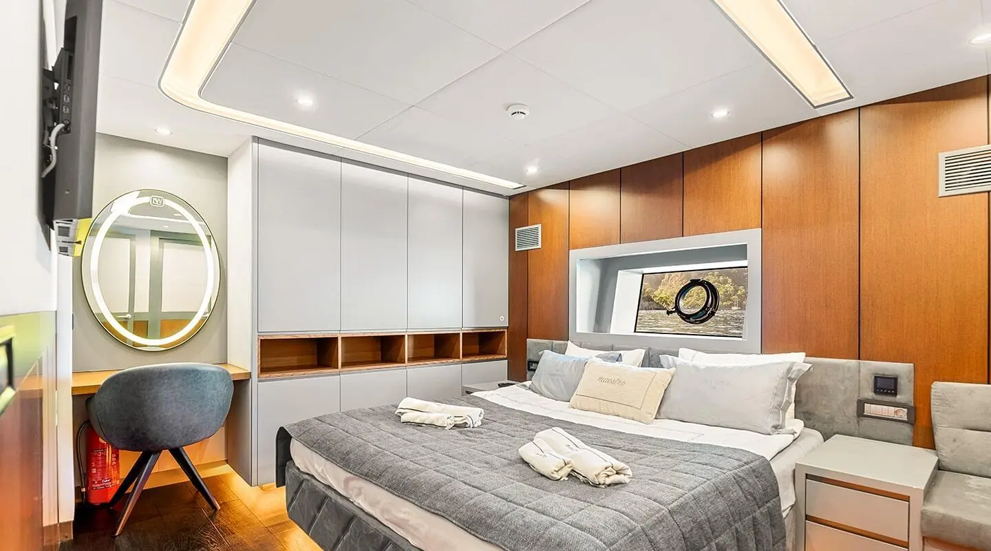Interior of North Wind yacht bedroom with bed, seating, and built-in storage