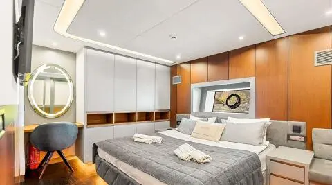 Interior of North Wind yacht bedroom with bed, seating, and built-in storage