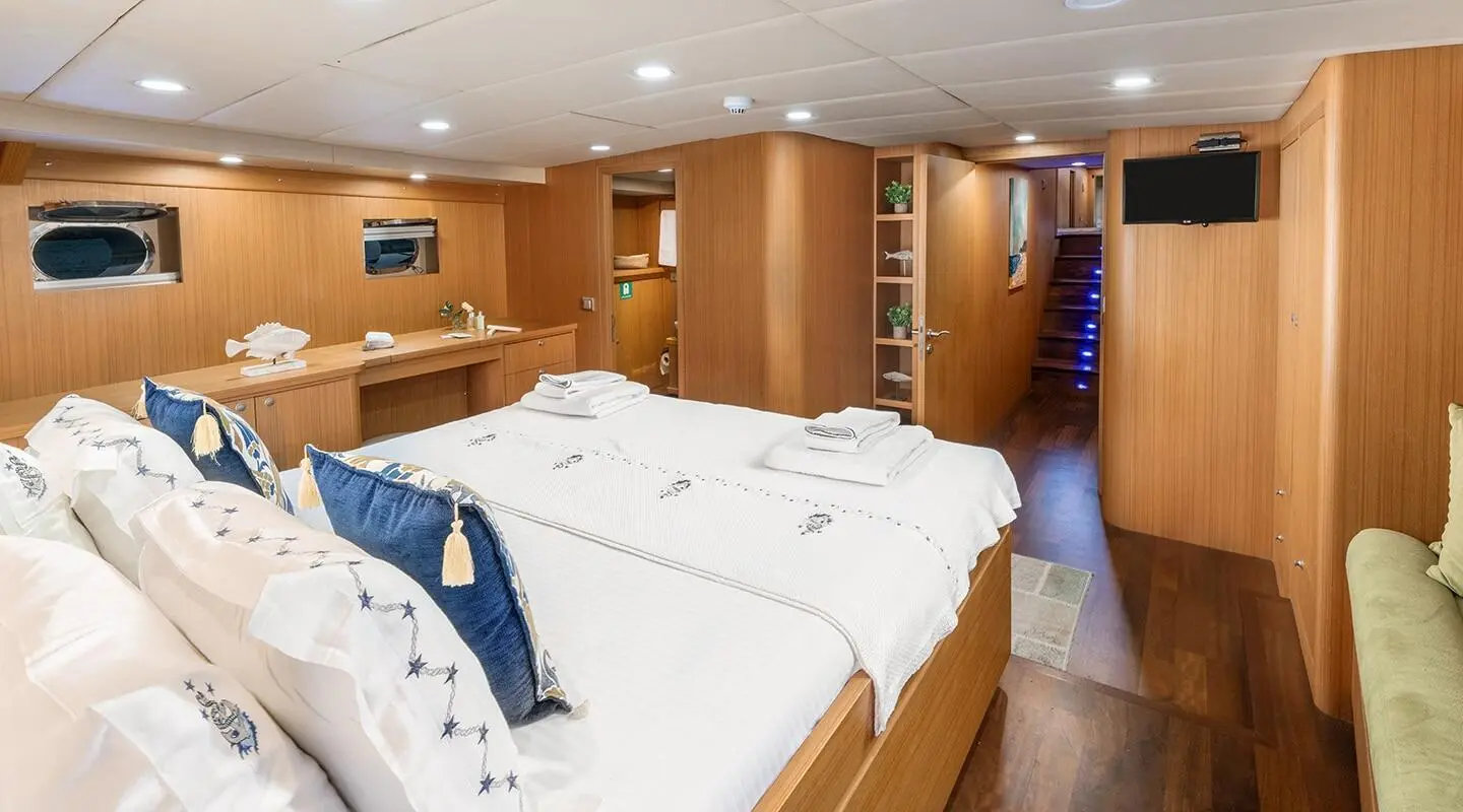 Artemis yacht interior with two twin beds, wood paneling, and porthole windows