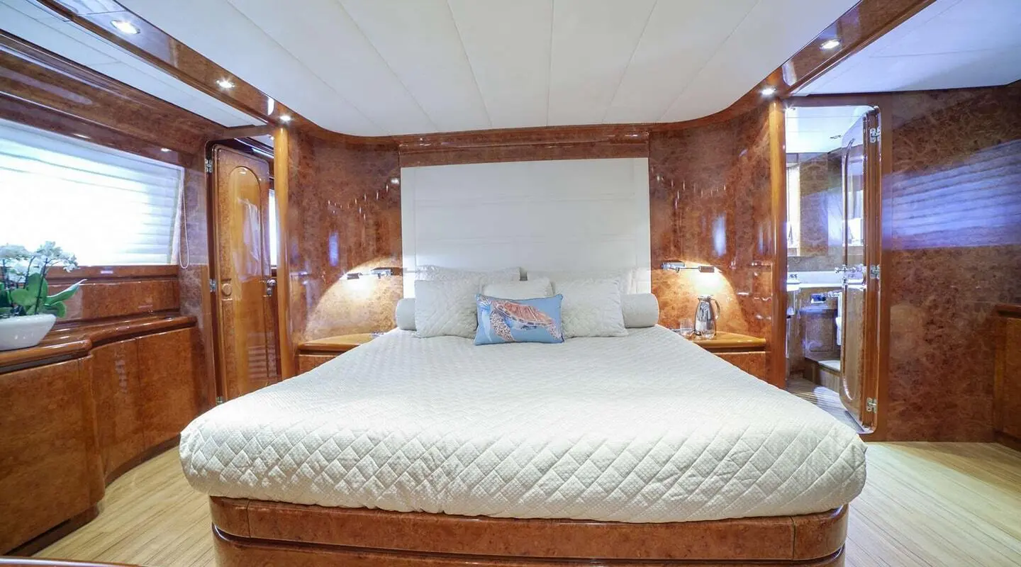 Interior view of a luxurious yacht cabin with a large bed and wooden accents