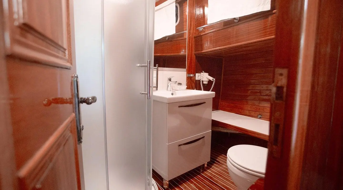 Interior view of Malena yacht bathroom with wooden panels, sink, and shower