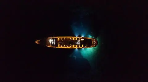 Dalmatino luxury yacht glowing at dusk, anchored in calm turquoise waters