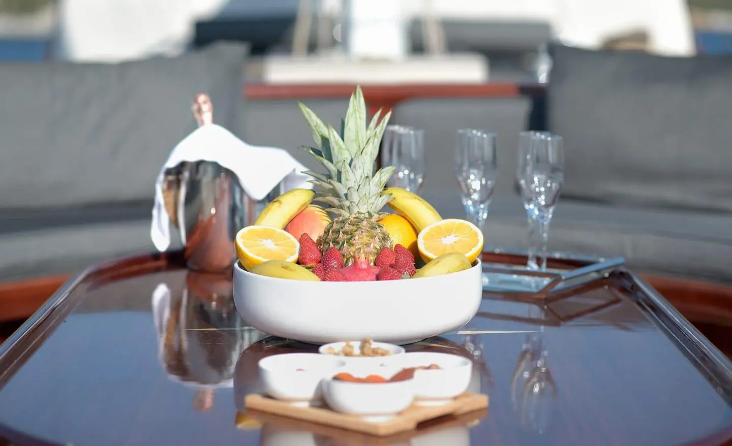 Luxurious yacht deck with a fruit bowl and champagne flutes on a glossy table