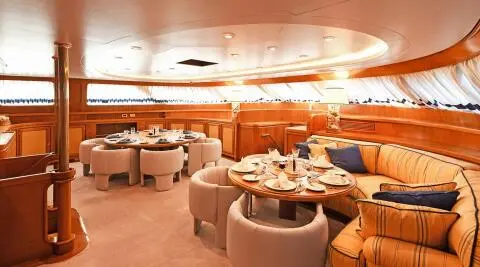 Tamarita luxury yacht dining saloon with round booths and tables
