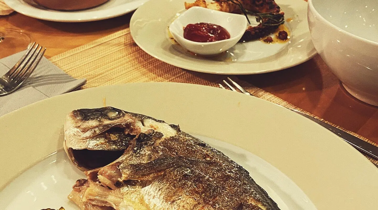 Silver Moon yacht dining scene with grilled fish on plate and sauces nearby