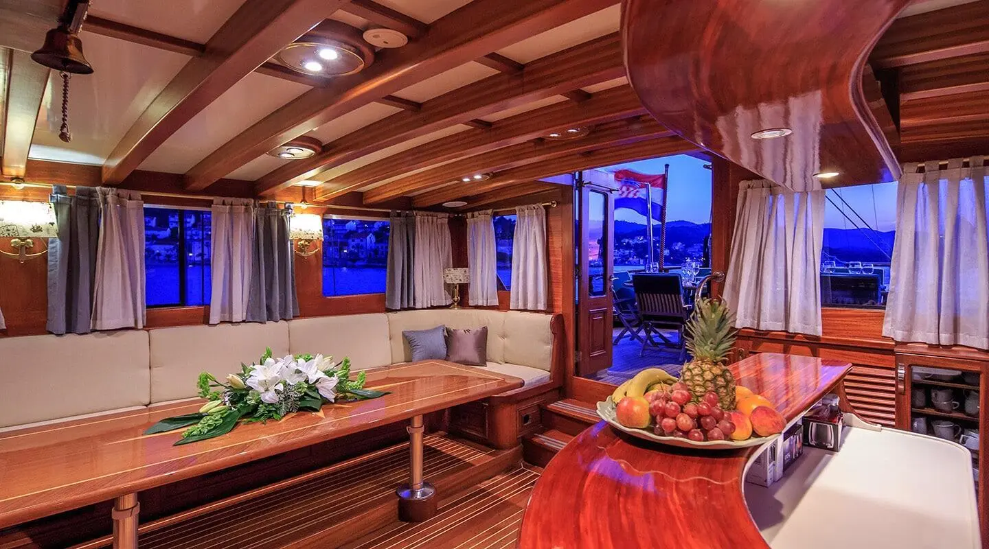 Carpe Diem 7 yacht interior lounge with wooden beams and cozy seating at dusk