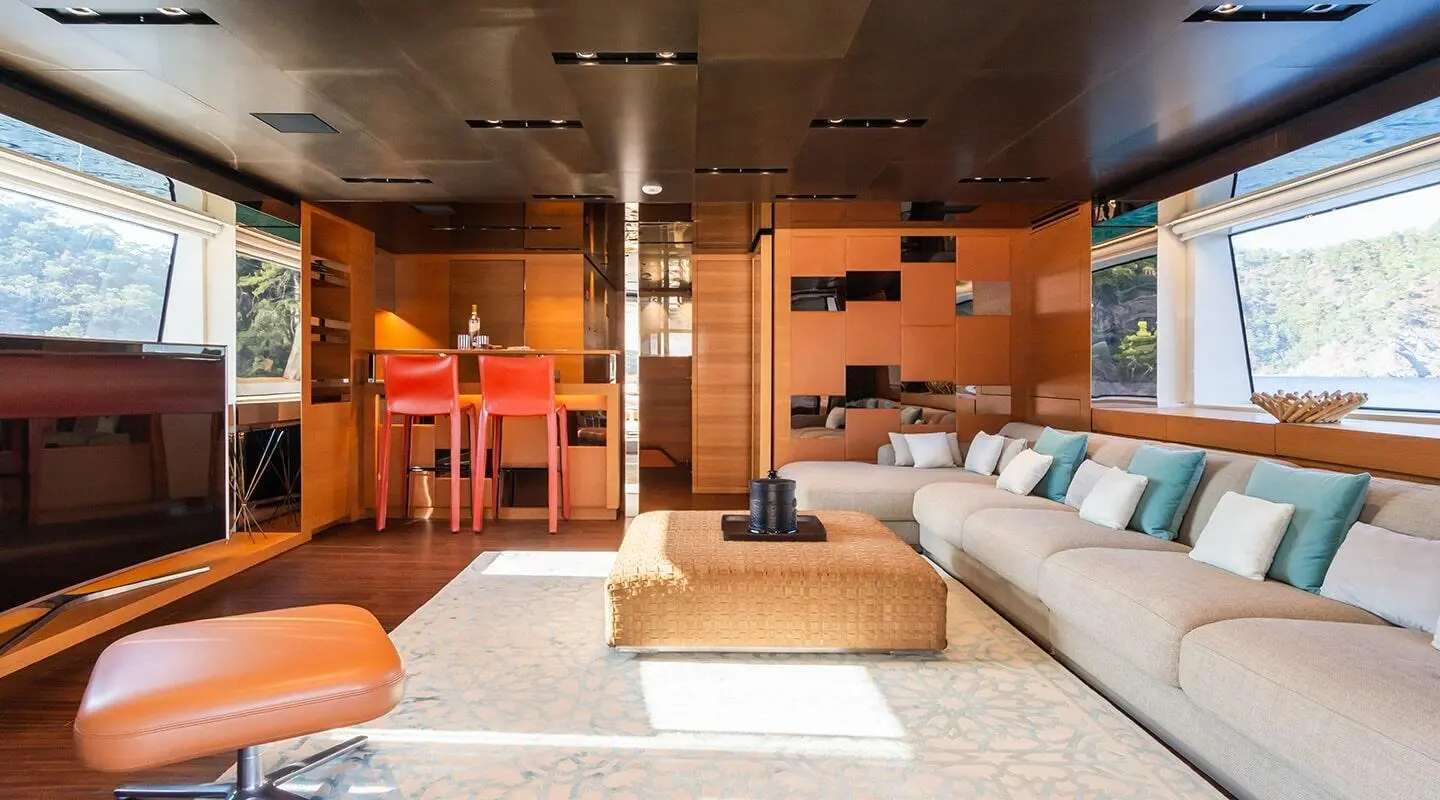 Takara One yacht saloon interior with seating, warm lighting and dark wood accents
