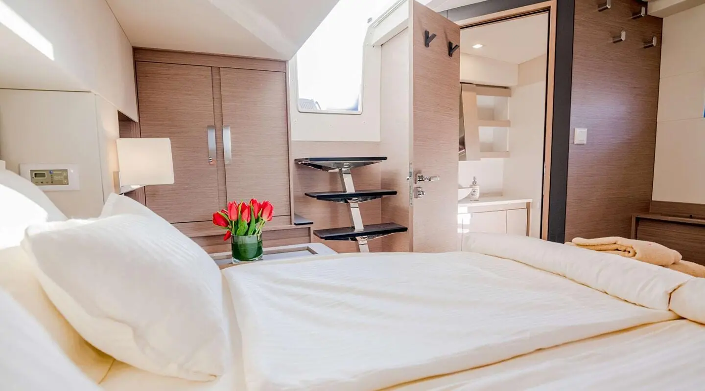 Bedroom inside with a red tulip bouquet on the bedside table and wooden cabinets