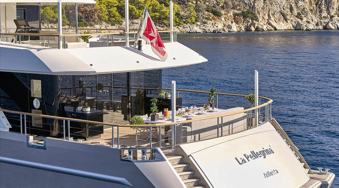 La Pellegrina 1 yacht docked at sunset with dining area on deck and water