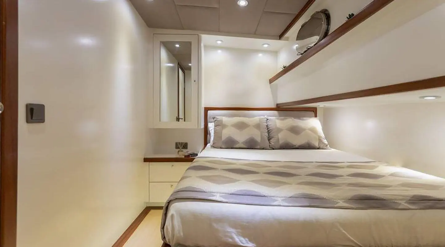 Interior of a yacht cabin with a bed, cabinets, and soft lighting aboard Grand Sailor