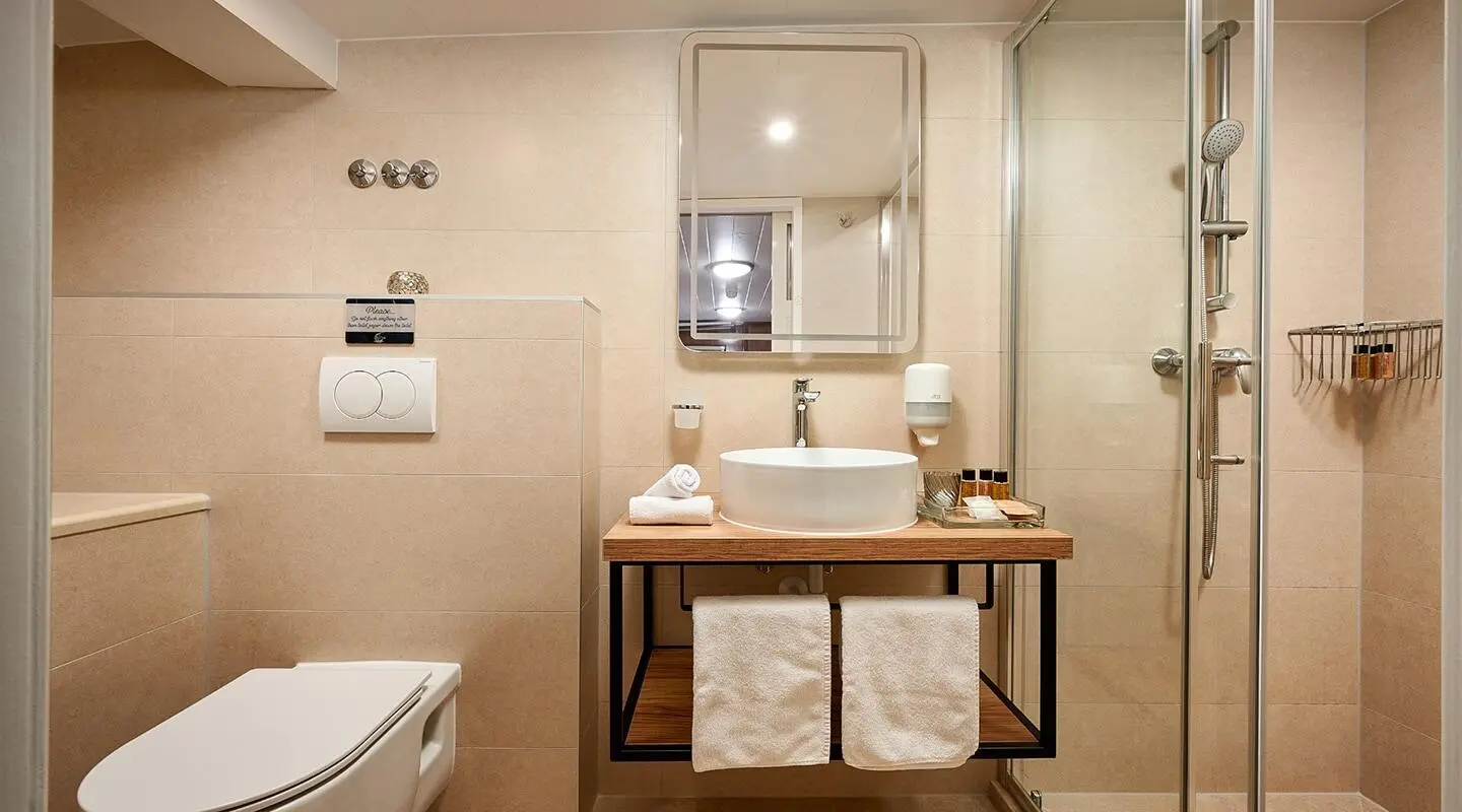 Luxurious yacht Luna bathroom scene with sink, mirror, and towels on a wooden vanity
