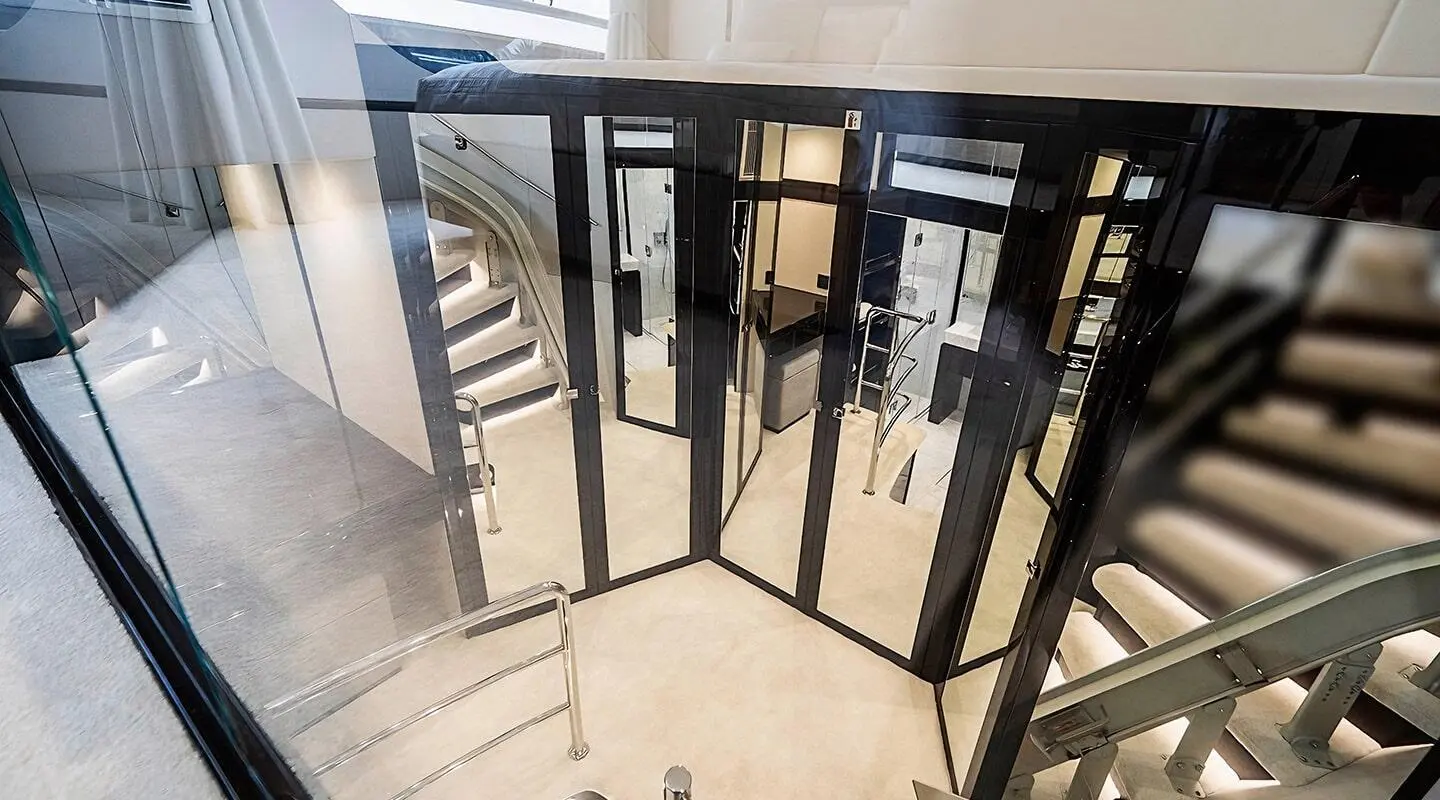 View from a glass door onto a sunlit deck of Quantum luxury yacht, railing visible