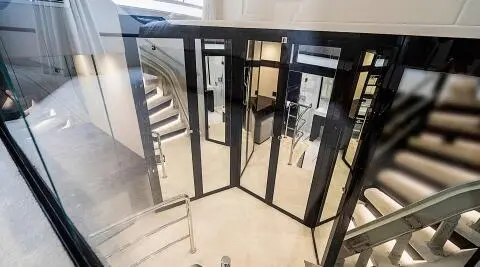 View from a glass door onto a sunlit deck of Quantum luxury yacht, railing visible