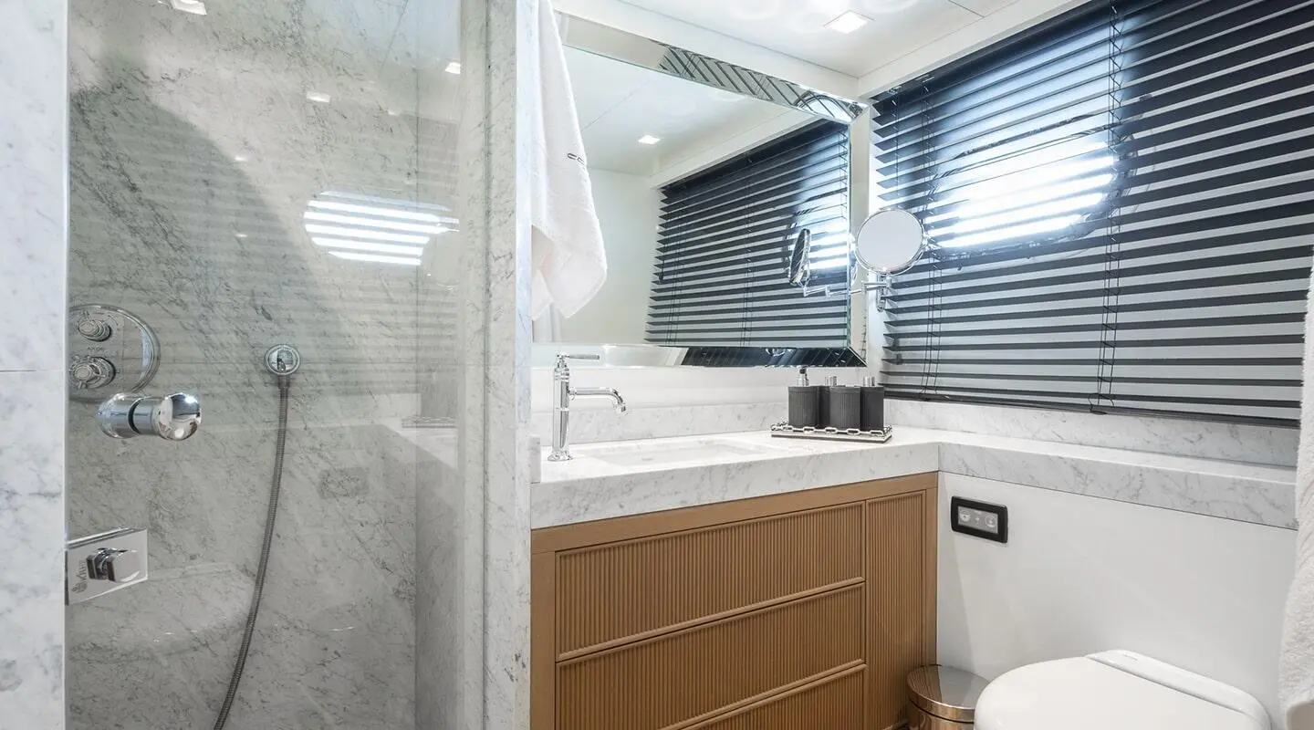 Illusion II yacht interior with white seating, wooden cabinetry, and windows