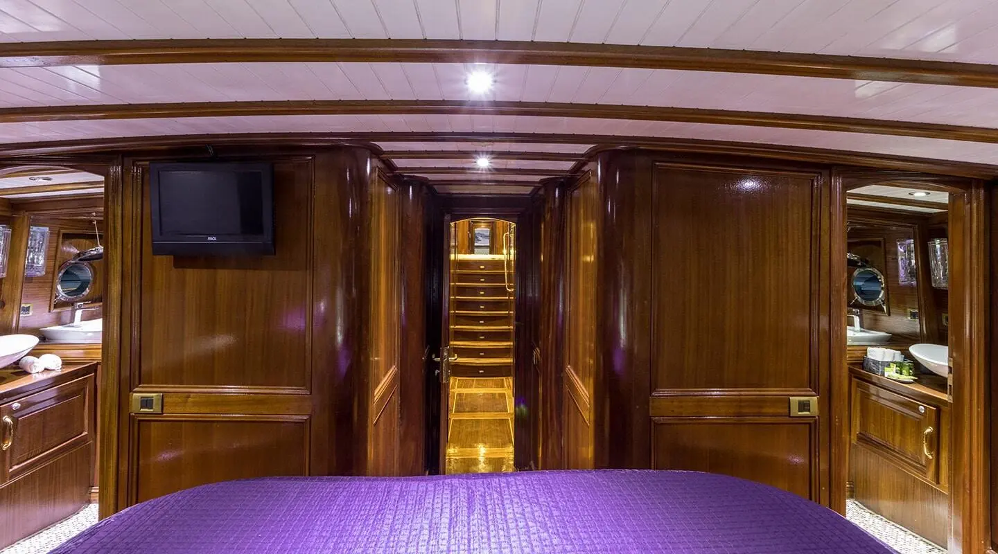 Grace 1 yacht interior with wooden stairs, cabin doorway, purple carpet