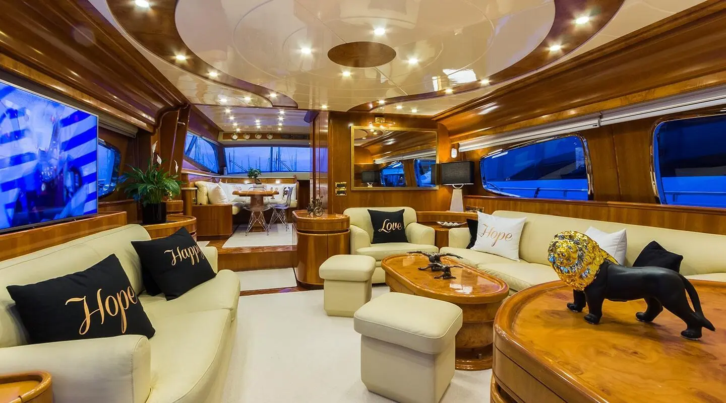 Interior of Amoraki yacht with plush cream seating, wood accents, and large windows
