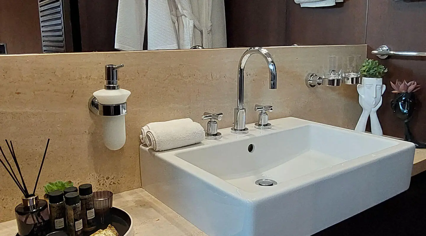 Yacht Miraval bathroom sink with faucet, soap dispenser, and towel near marble counter