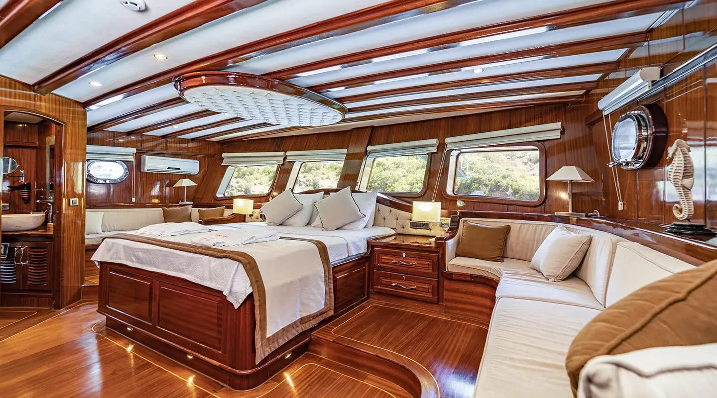 Luxurious yacht interior with polished wooden deck, white cushions, and large windows