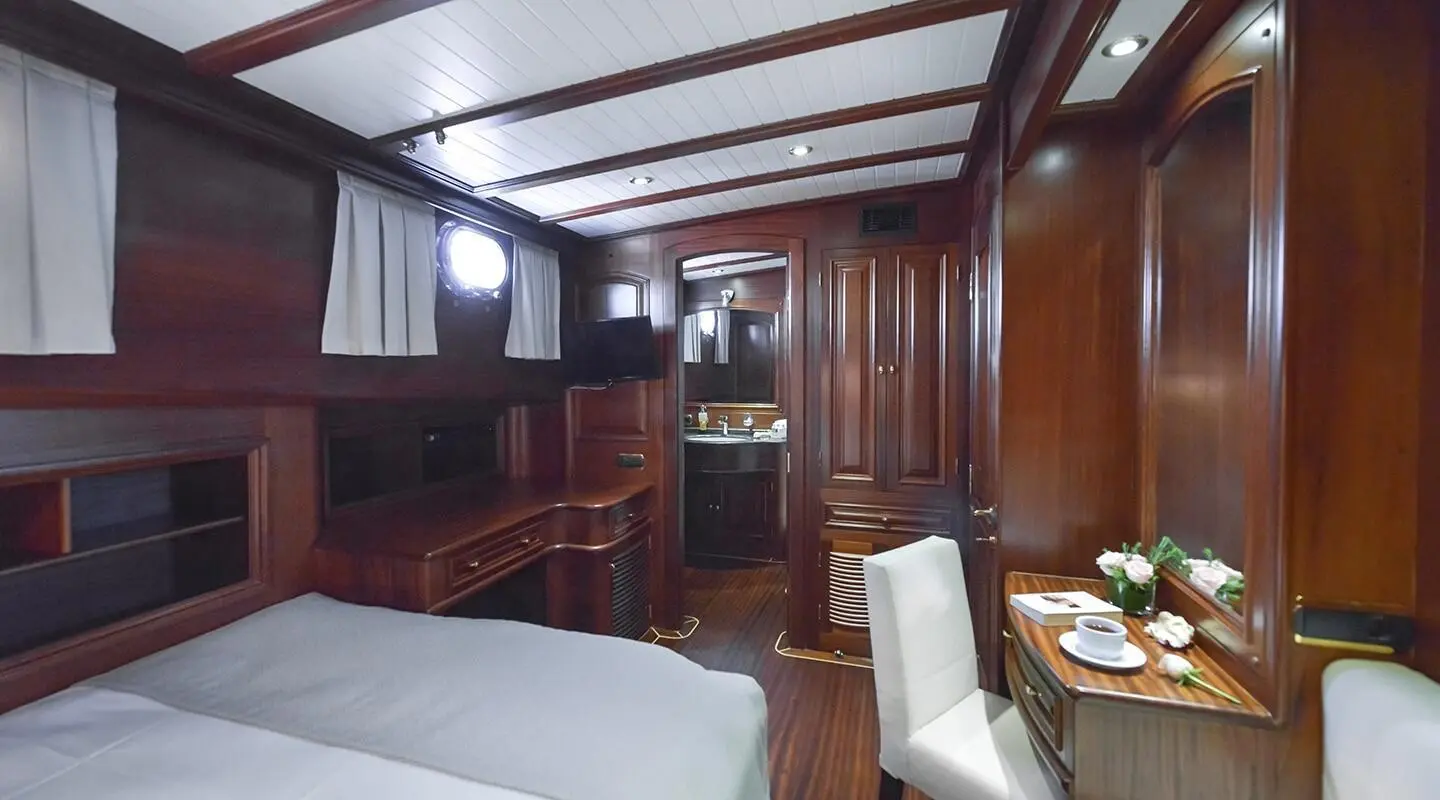Interior of Lady Christa yacht with polished wood panels and blue cushions