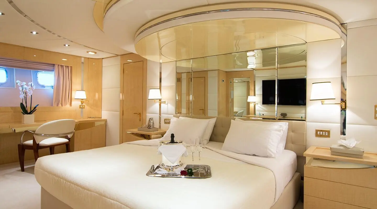 O'Natalina yacht interior with a luxurious bed and wooden accents