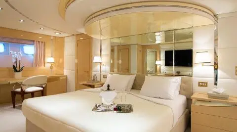 O'Natalina yacht interior with a luxurious bed and wooden accents