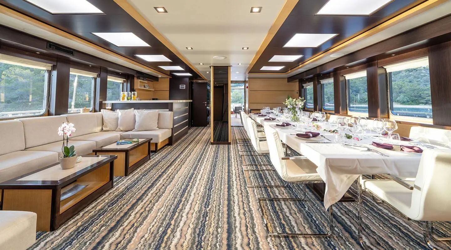 Navilux yacht salon interior with seating, tables, and large windows