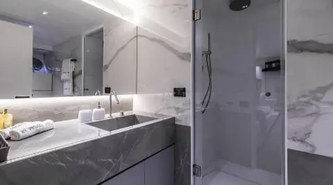 Luxurious yacht bathroom on Project Steel featuring marble countertops and a glass shower