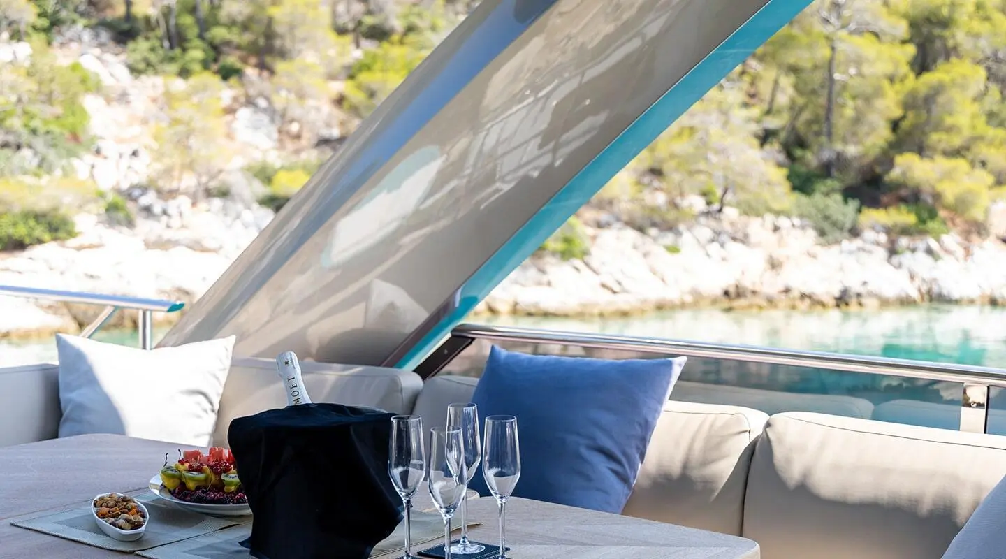 Vista motor yacht sundeck with blue cushions and glassware on table