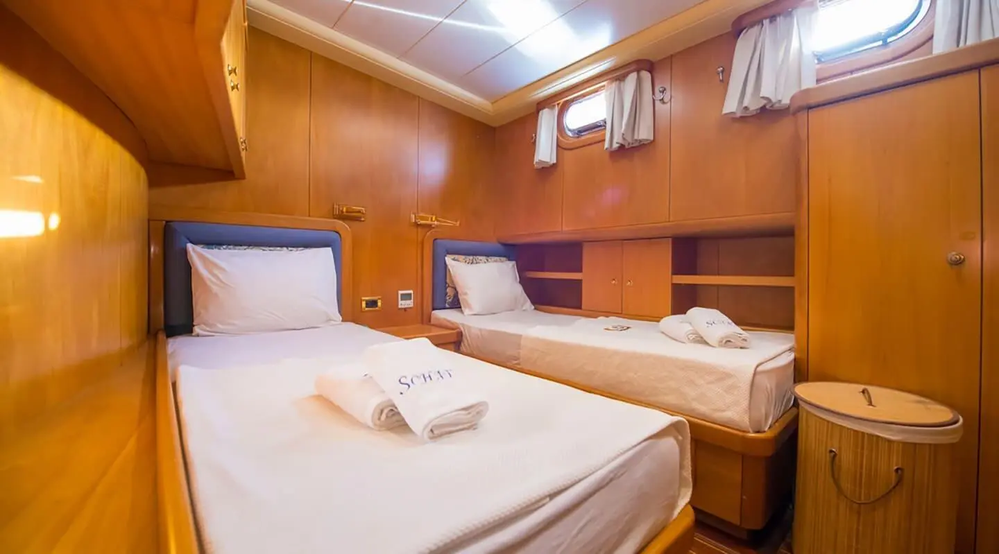 Interior of a wooden cabin with two twin beds and towels