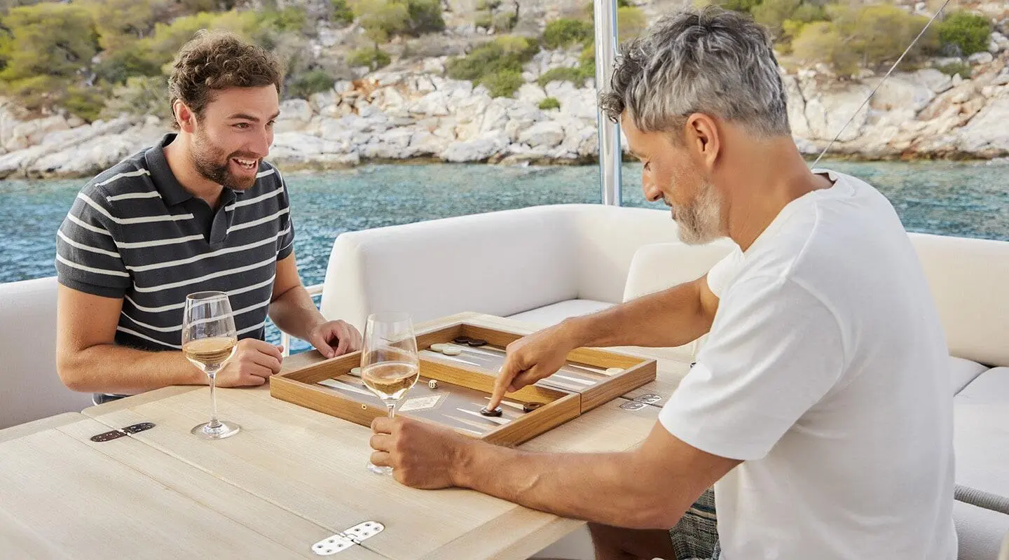 Daiquiri yacht crew on deck around a table with board games and cards