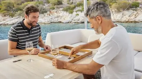 Daiquiri yacht crew on deck around a table with board games and cards