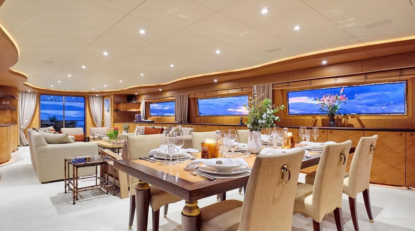Mobius yacht dining area with table set, warm lighting, and large windows