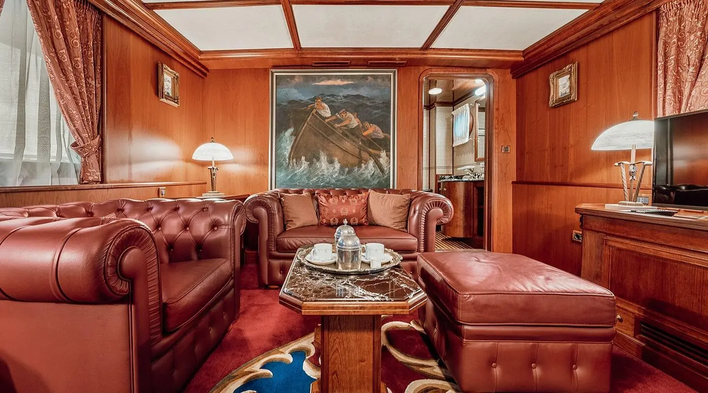 Cozy yacht cabin with leather seating, wooden panels, and a central table
