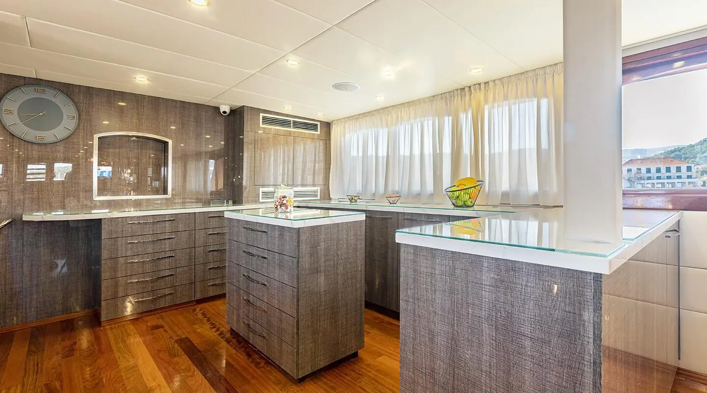 Spacious yacht saloon with two island countertops and warm wood floors