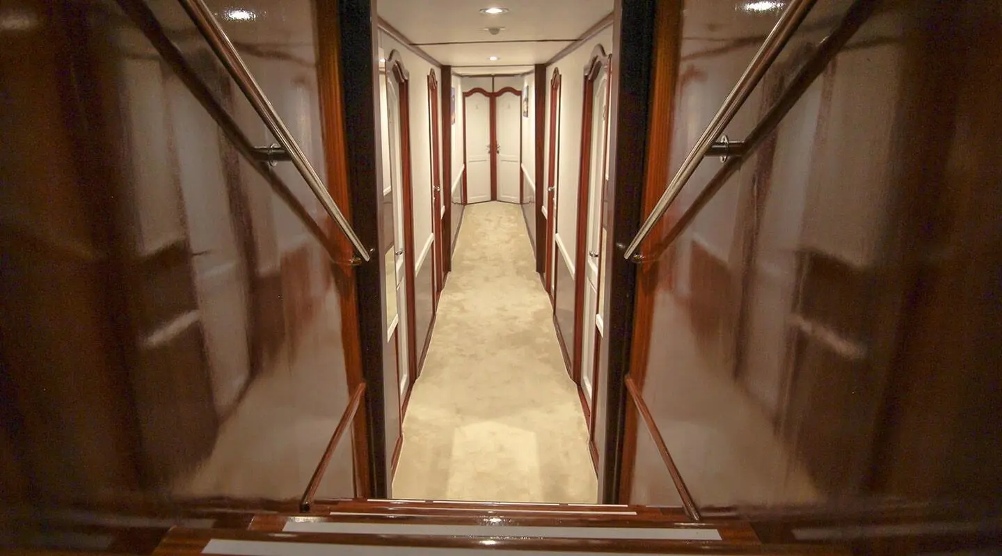 A luxurious yacht interior corridor on Aurum with polished wood panels