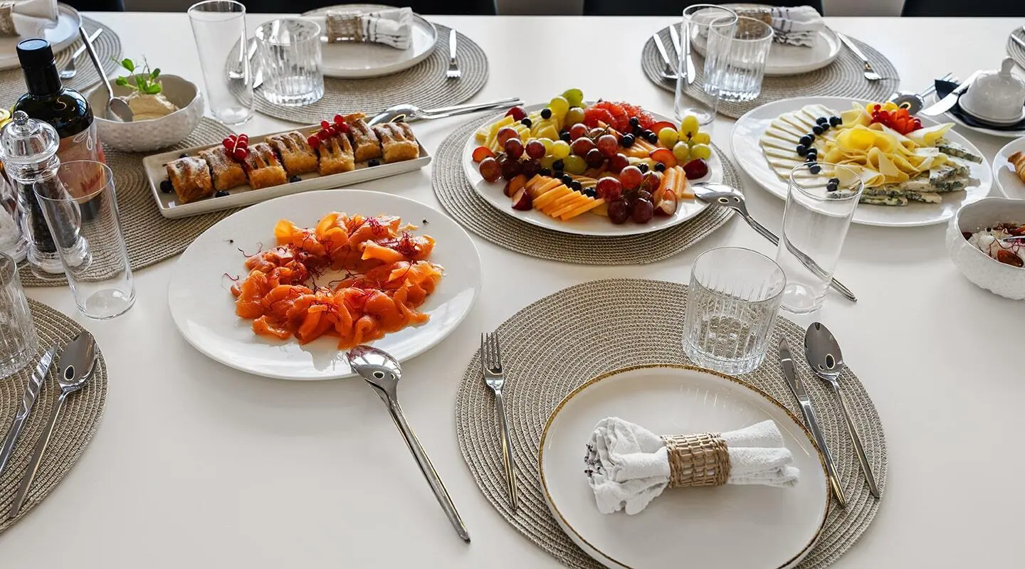 Maxita yacht aboard dining table with assorted fruit and cheese platters onboard