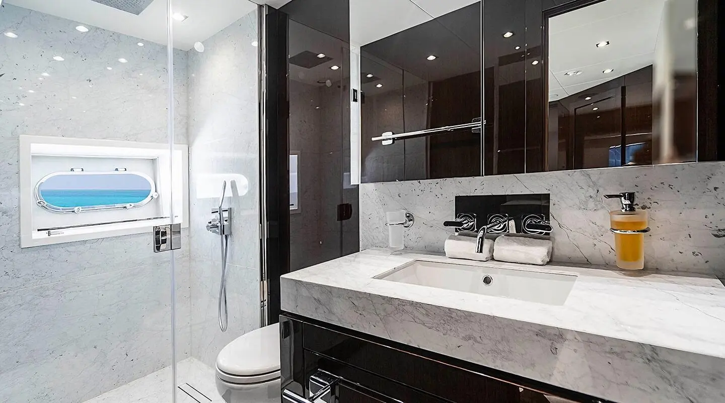 Luxurious yacht Quantum bathroom with marble sink, dark cabinets, and mirror