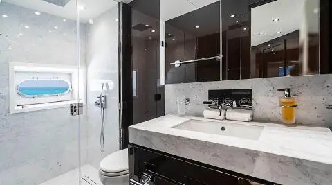 Luxurious yacht Quantum bathroom with marble sink, dark cabinets, and mirror