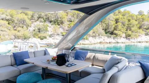 Vista yacht sundeck dining area with seating, table, and shade sails