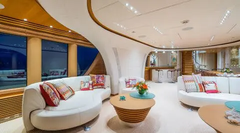 Interior of Serenity yacht saloon with curved white furnishings and wooden accents