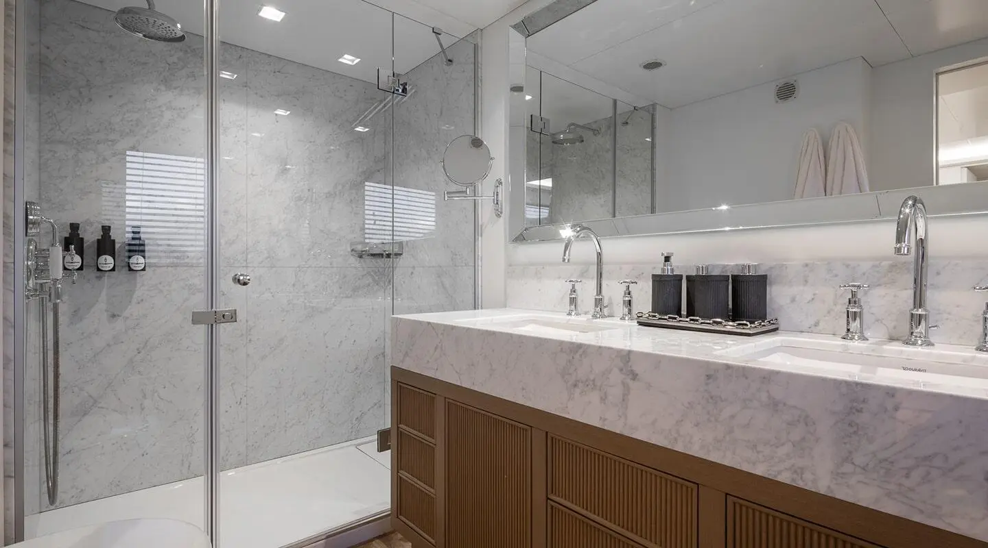 Luxurious marble bathroom with double sinks and glass shower on yacht Illusion II