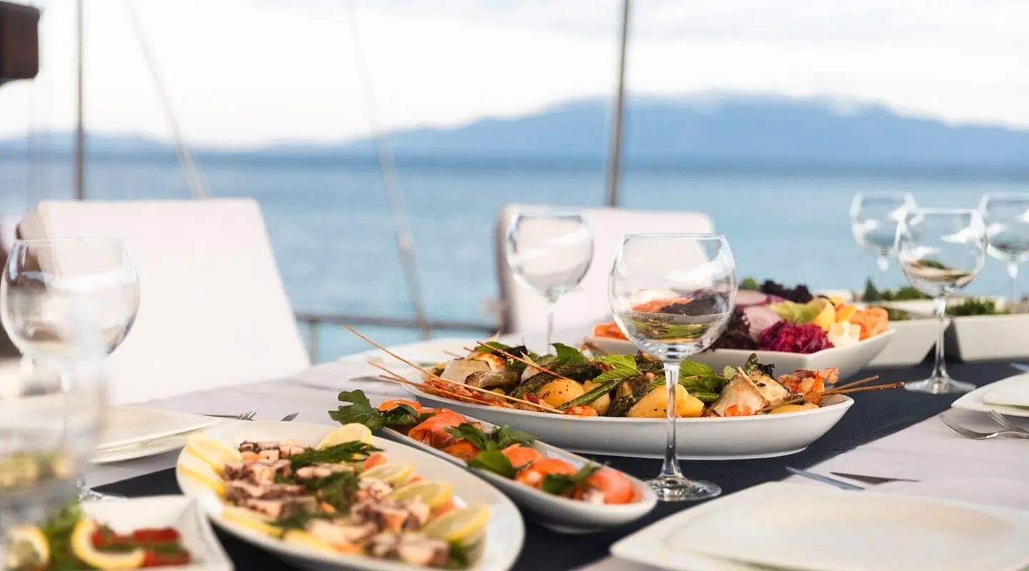 Yacht Estrella De Mar scene with a table of assorted plated dishes on deck at sunset