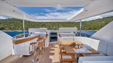 Outdoor yacht lounge on Aluminia Too with seating, table, and ocean view