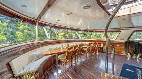 Cesarica yacht interior deck at sunset with wooden railings and seating