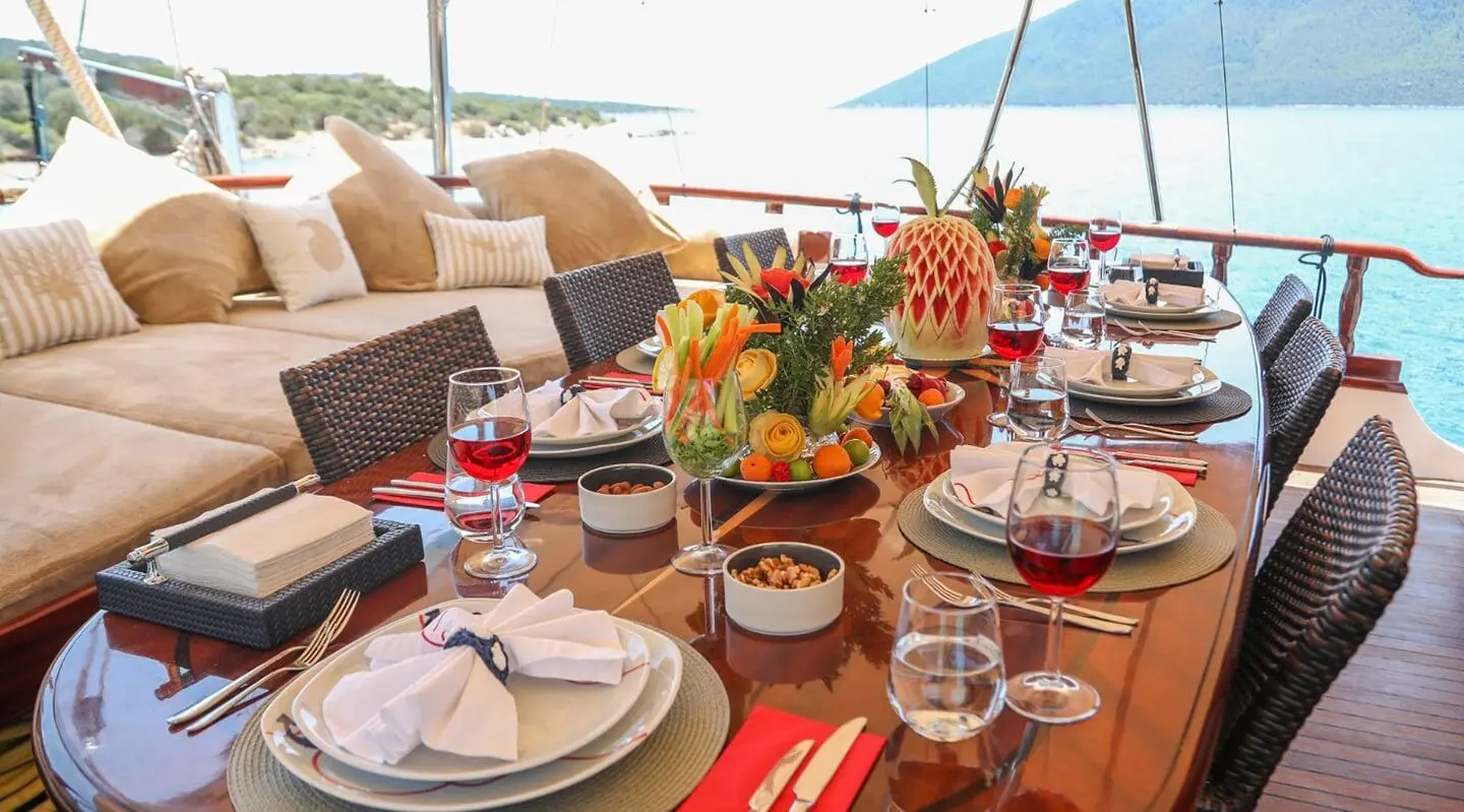 Table set for dining on a yacht with flowers and fruit centerpiece